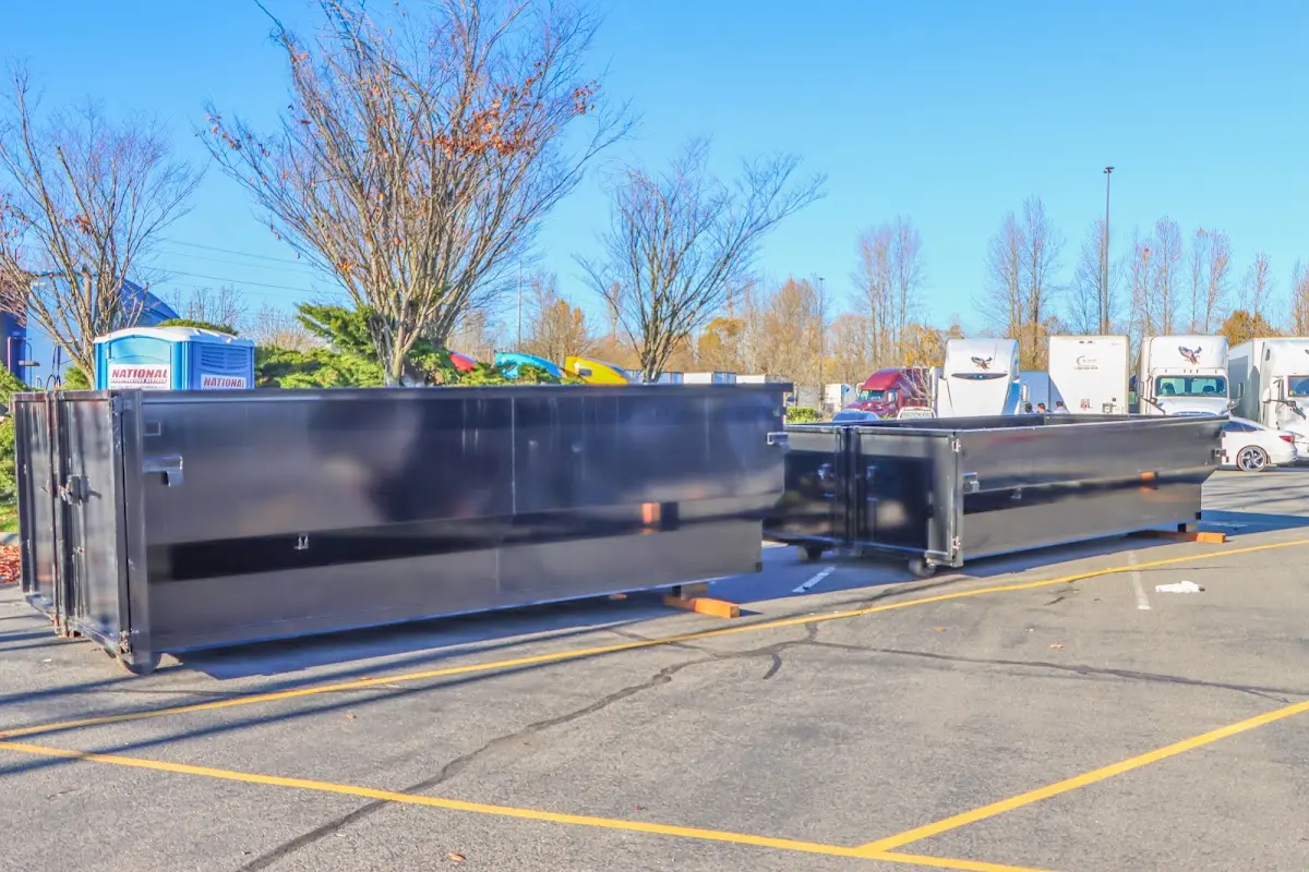 Professional dumpster rental service with roll-off container on residential driveway in Vermillion